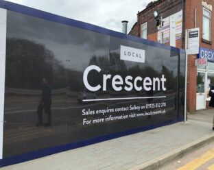 Construction hoarding displaying the project name "Local Crescent" with contact details for sales inquiries and a website link.