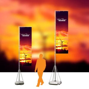 Two tall premium sail flags featuring a vibrant sunset with a wind turbine, set against a dramatic sky, with a silhouette of a person walking nearby.