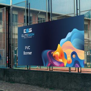 A large PVC banner with vibrant abstract artwork, displayed outdoors against a metal fence.