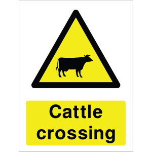 Warning sign with a yellow triangle containing a cow silhouette and the words “Cattle crossing” in bold black on yellow background