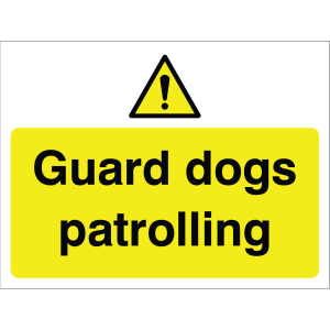 Outdoor warning sign with warning triangle icon and message "Guard dogs patrolling" in black on yellow background