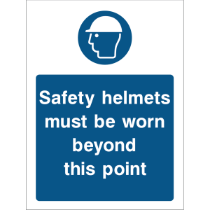Blue warning sign with an icon of a person wearing a safety helmet and the message “Safety helmets must be worn beyond this point”