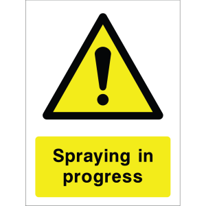 Warning sign with a yellow triangle containing an exclamation mark and the words “Spraying in progress” in bold black on yellow background