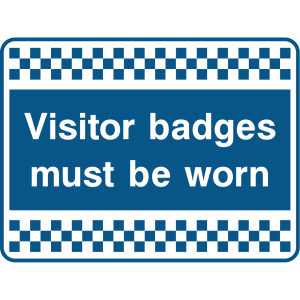 Outdoor warning sign with checkered border and text: "Visitor badges must be worn"